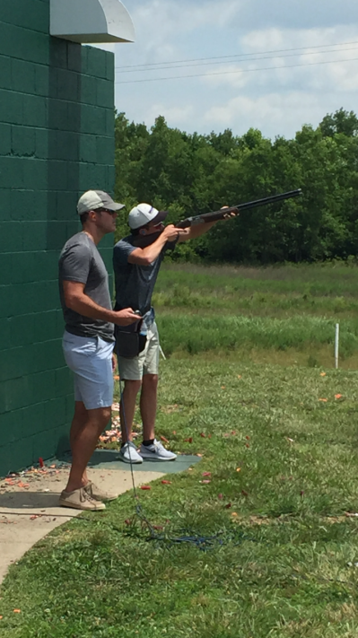 Dr. Bruce B. Fry aiming during a skeet shooting session on a sunny day outdoors